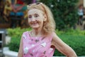 Happy Caucasian Senior woman wear pink sun glasses at the amusement park Royalty Free Stock Photo