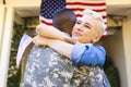 Happy caucasian woman and biracial male american soldier embracing outside the house Royalty Free Stock Photo