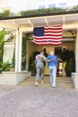 Happy caucasian woman and biracial male american soldier embracing outside the house Royalty Free Stock Photo