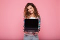 Young lady pointing at copy space on laptop isolated over pink Royalty Free Stock Photo