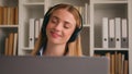Happy Caucasian woman girl office worker listen to music in headphones enjoy song with laptop service work pause dancing Royalty Free Stock Photo