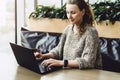 Happy woman millennial using laptop while sitting at cafe.Young businesswoman sitting in coffee shop,working on computer