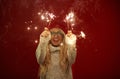 Happy caucasian woman with sparklers in her hands is joyful, has a good mood, expresses sincere cheerful emotions, have