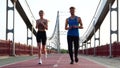 Happy Caucasian young couple of friends running together working out outdoors. Male and female athletes run on the Royalty Free Stock Photo