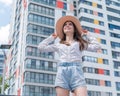 Happy caucasian young woman in a hat and shorts walks on a city street on a hot summer day Royalty Free Stock Photo