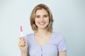 Happy caucasian young woman holding pregnancy test and smilind friendly Royalty Free Stock Photo