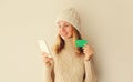 Happy caucasian young woman shopping online or ordering something looking at smartphone holding plastic credit bank card in hands Royalty Free Stock Photo