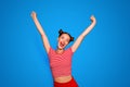 Happy celebrating winning success woman isolated on red baskground with arms raised up above her head. Success and life Royalty Free Stock Photo