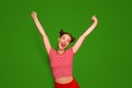 Happy celebrating winning success woman  on red baskground with arms raised up above her head. Success and life Royalty Free Stock Photo