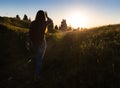 Happy celebrating winning success woman at sunset or sunrise standing elated with arms raised up above her head in Royalty Free Stock Photo