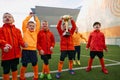 Happy champions. Group of little boys, children in uniform, football players raising award, trophy. Kids training on Royalty Free Stock Photo