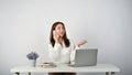 A happy Asian businesswoman is on the phone with her business client while sitting at her desk Royalty Free Stock Photo