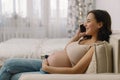 Happy charming pregnant woman using mobile phone. Pregnant Woman