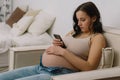 Happy charming pregnant woman using mobile phone. Pregnant Woman Royalty Free Stock Photo