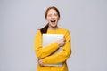 Happy young woman student holding laptop computer with closed eyes on isolated gray background. Royalty Free Stock Photo