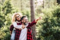 Happy cheerful adult beautiful couple have fun together and joy in the wood forest - concept of love and friendship with people - Royalty Free Stock Photo