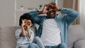 Happy cheerful african american mature father playing with cute daughter sitting in room on sofa smiling dad and little Royalty Free Stock Photo