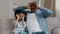 Happy cheerful african american mature father playing with cute daughter sitting in room on sofa smiling dad and little Royalty Free Stock Photo