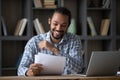 Happy cheerful African student guy reading admission letter from school Royalty Free Stock Photo