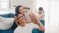 Happy cheerful Asian family dad, mom and daughter having fun cuddling playing on floor while birthday at house. Self-isolation,