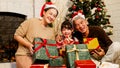 Happy and cheerful Asian family gathering, wearing Santa hats talking and smiling. Exchanging gifts, grandparents and grandson Royalty Free Stock Photo