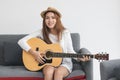 Happy cheerful Asian woman playing acoustic guitar in living room. Music lover concept Royalty Free Stock Photo