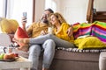 Happy and cheerful beautiful adult caucasian couple do a video call conference using phone online connection at home during Royalty Free Stock Photo