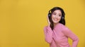 Happy cheerful Beautiful Asian woman wearing wireless headphones enjoying listening to music on yellow background.People lifestyle Royalty Free Stock Photo