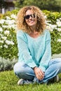 Happy and cheerful beautiful caucasian adult woman enjoy the park and smile at the camera with green natural daisy in background Royalty Free Stock Photo