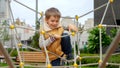 Happy cheerful boy climbing through ropes and nets on the public playground. Active child, sports and development, kids playing Royalty Free Stock Photo