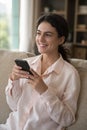 Happy cheerful cellphone user girl sitting on home sofa Royalty Free Stock Photo