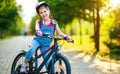 Happy cheerful child girl riding a bike in Park in nature