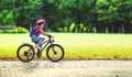 Happy cheerful child girl riding a bike in Park in nature Royalty Free Stock Photo