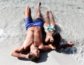 Happy cheerful couple having fun lying on sand beach sea shore together. Romantic vacation, honeymoon love Royalty Free Stock Photo