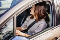 Happy cheerful curly smiling young woman driving her car in the city Royalty Free Stock Photo