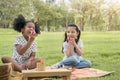 Happy cheerful ethnic girls eat apple together at outdoors park , Relationship little kids, Diverse ethnic concept Royalty Free Stock Photo