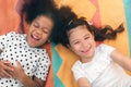 Happy cheerful ethnic girls  laying on mat at outdoors park, Her smiling and laughing together, Relationship little kids, Diverse Royalty Free Stock Photo