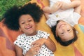 Happy cheerful ethnic girls  laying on mat at outdoors park, Her smiling and laughing together, Relationship little kids, Diverse Royalty Free Stock Photo