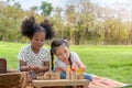 Happy cheerful ethnic girls play wooden block puzzle together at outdoors park , Relationship little kids, Diverse black and white Royalty Free Stock Photo