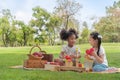 Happy cheerful ethnic girls play wooden block puzzle together at outdoors park , Relationship little kids, Diverse black and white Royalty Free Stock Photo