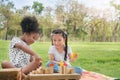 Happy cheerful ethnic girls play wooden block puzzle together at outdoors park , Relationship little kids, Diverse ethnic concept Royalty Free Stock Photo