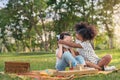 Happy cheerful ethnic girls play wooden block puzzle together at outdoors park , They wear masks to protect them from virus, Royalty Free Stock Photo