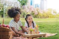 Happy cheerful ethnic girls play wooden block puzzle together at outdoors park, White and black together concept, Relationship Royalty Free Stock Photo
