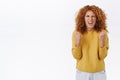 Happy, cheerful and excited pretty redhead curly woman fist pump, say yes in approval and happieness squinting satisfied
