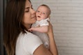 Happy cheerful family. Mom and baby kiss, laugh and hug. Royalty Free Stock Photo