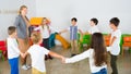 Positive female teacher playing circle game with children in classrom Royalty Free Stock Photo