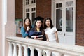 Happy and cheerful Female university graduate students in academic dress chat with friends who came to congratulate on Royalty Free Stock Photo