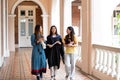 Happy and cheerful Female university graduate students in academic dress chat with friends who came to congratulate on Royalty Free Stock Photo