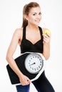 Happy cheerful fitness woman holding weight scales and green apple Royalty Free Stock Photo