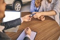 Happy cheerful girl getting a car key with handsome man in showroom. Business concept and car selling Royalty Free Stock Photo